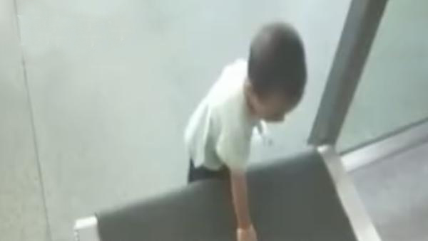 小孩用手摸安檢機傳送帶